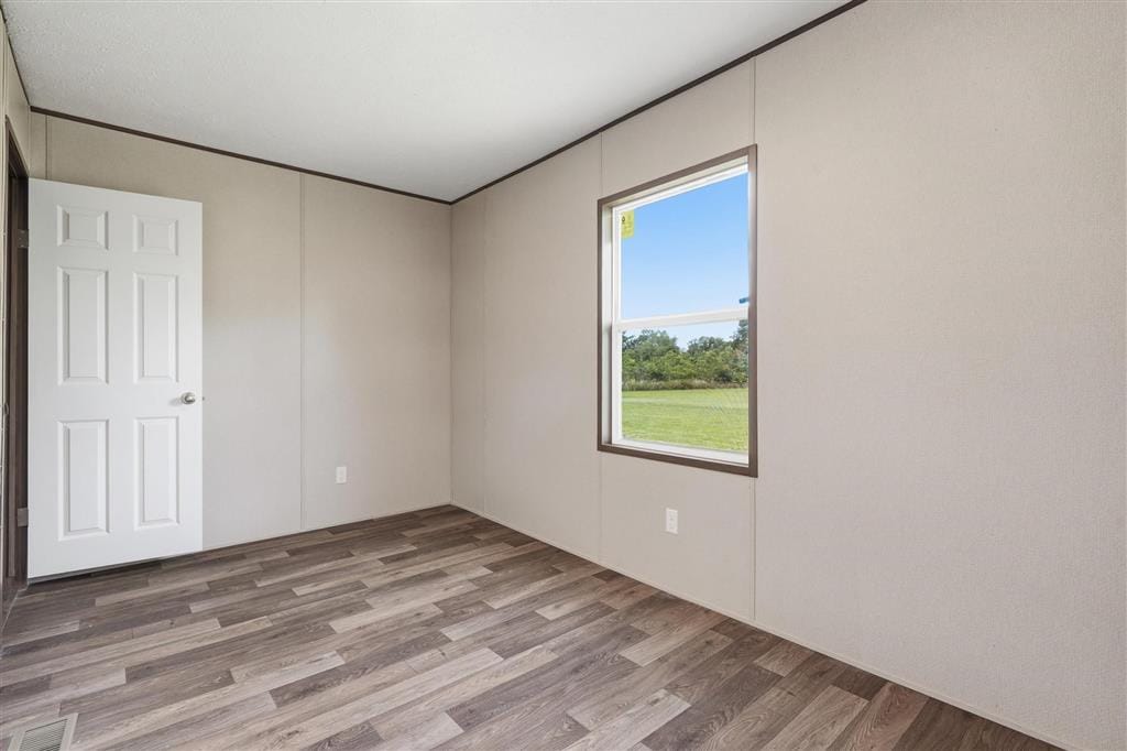 Bedroom with wood-look flooring and an exterior window