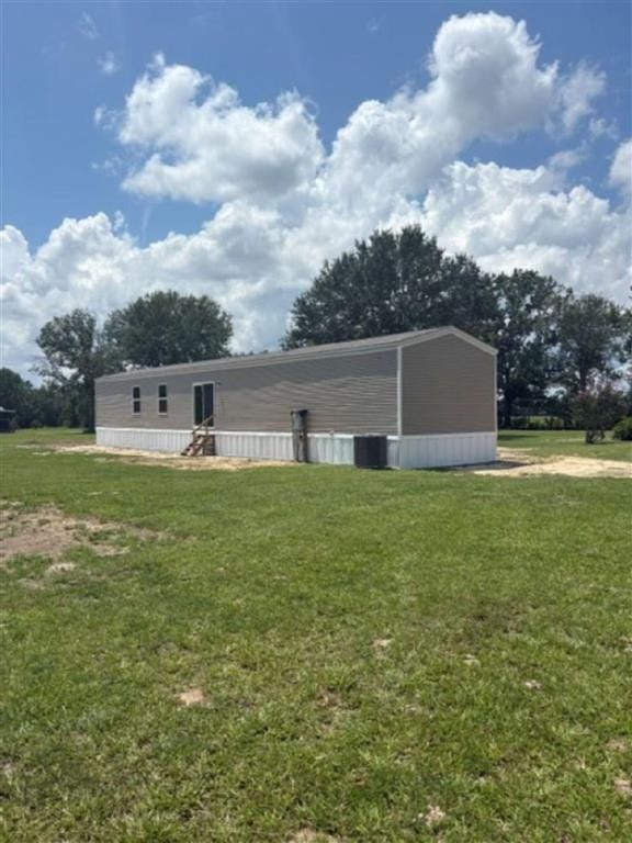 Rear exterior of the new home on a grassy lot with mature trees behind