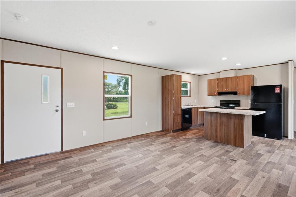 Open living room flowing into the kitchen with wood-look flooring