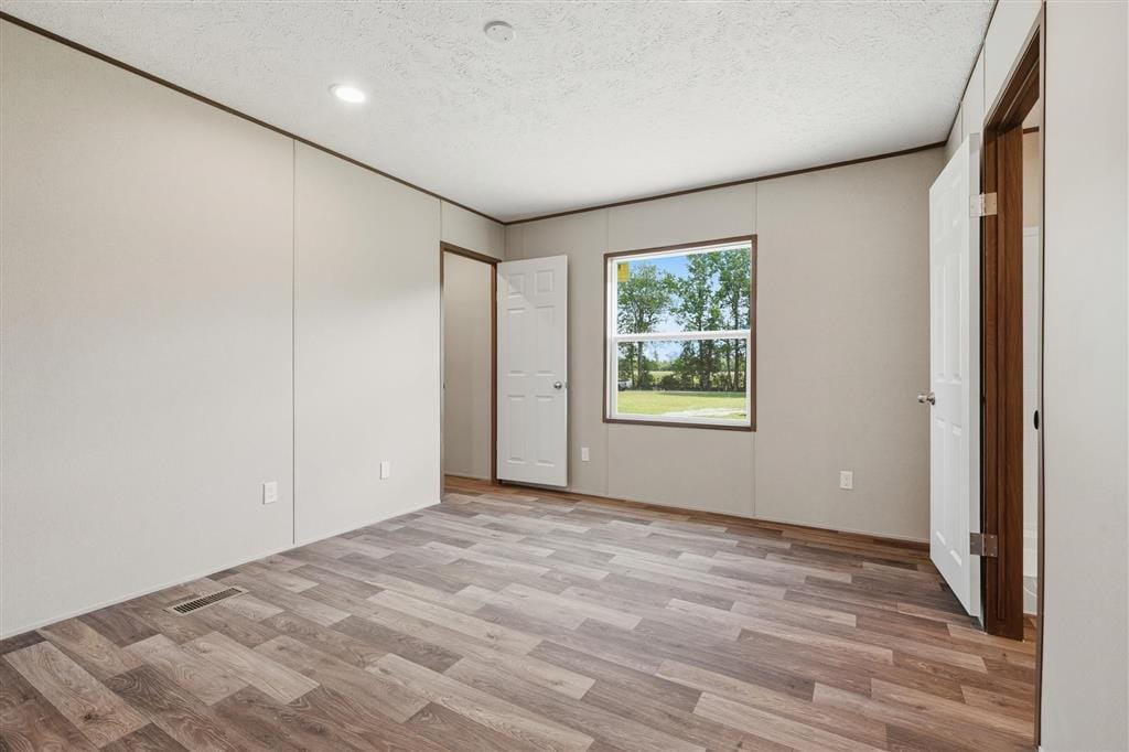 Bedroom with wood-look flooring and a window facing the yard