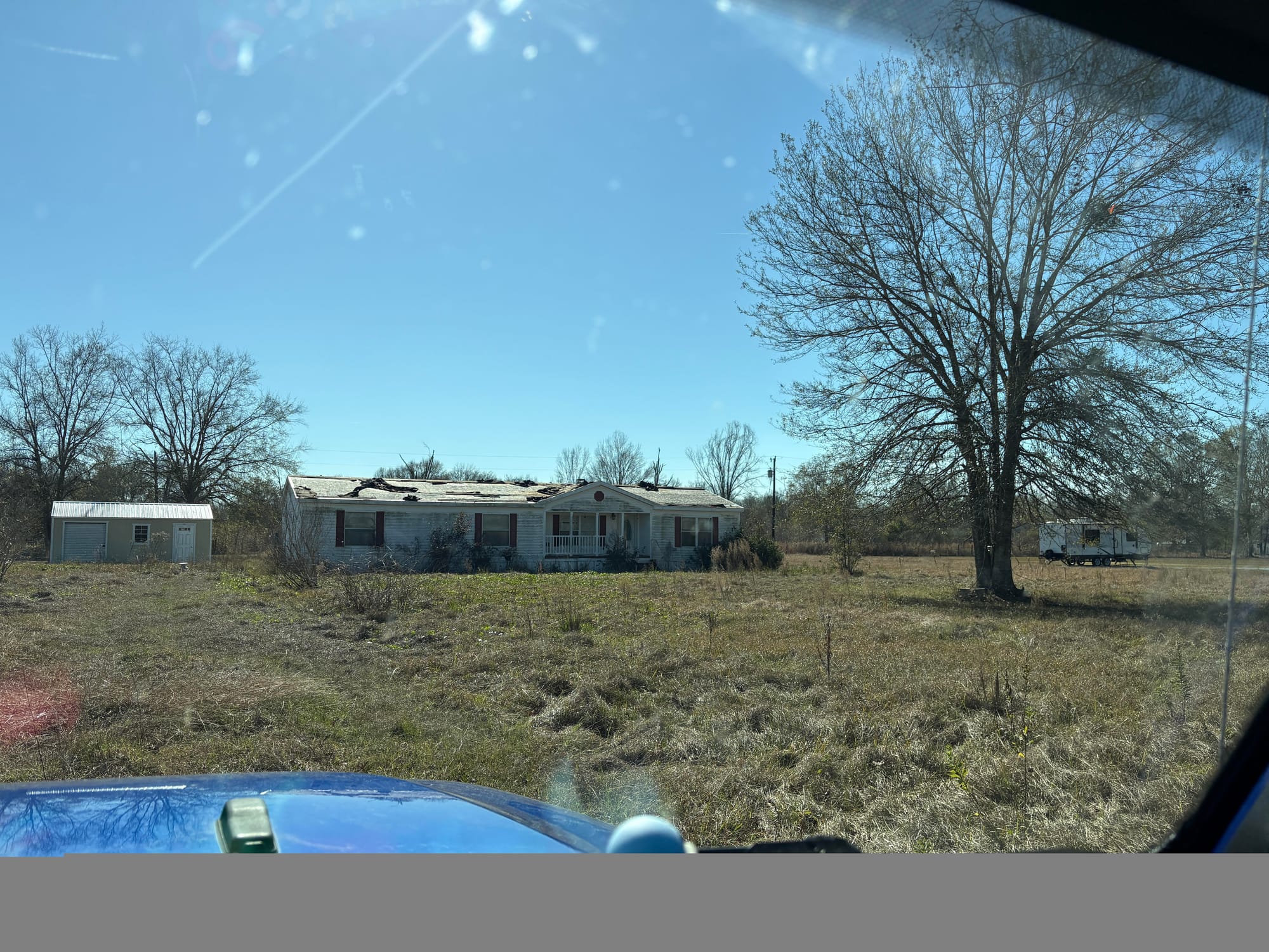 Before: the hurricane-damaged home at 1425 Foreman Road standing on overgrown land before the renovation